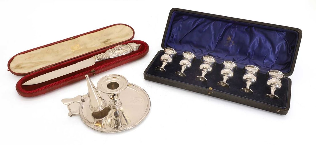 A cased set of six silver goblets,: A cased set of six silver goblets, by Charles S Green & Co Ltd, Birmingham, 1918, together with silver chamberstick, London, 1792, and a silver handled cake knife, London 16cm, 12ozt without knife