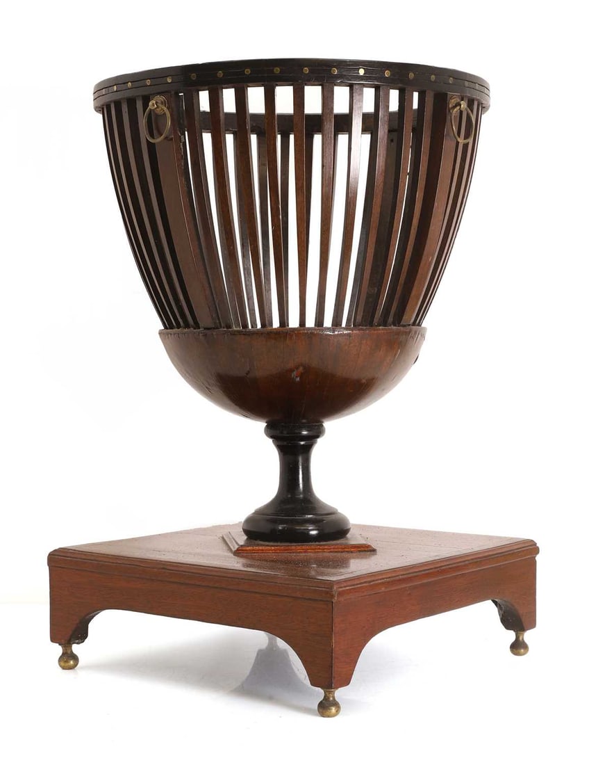 A rosewood jardinière of basket form, 19th century,: A rosewood jardinière of basket form, 19th century, the studded rim over a turned and ebonsided column upon a brass strung platform base, with brass drop feet 36cm wide, 51cm high Condition