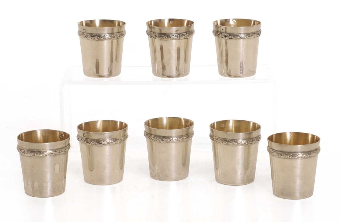 A group of eight silver cups, by Jean Puiforcat, 20th century, French,: A group of eight silver cups, by Jean Puiforcat, 20th century, French, the plain and tapering body decorated with a single leaf decorated band, marked with a minerva head to the rim, as well as anothe