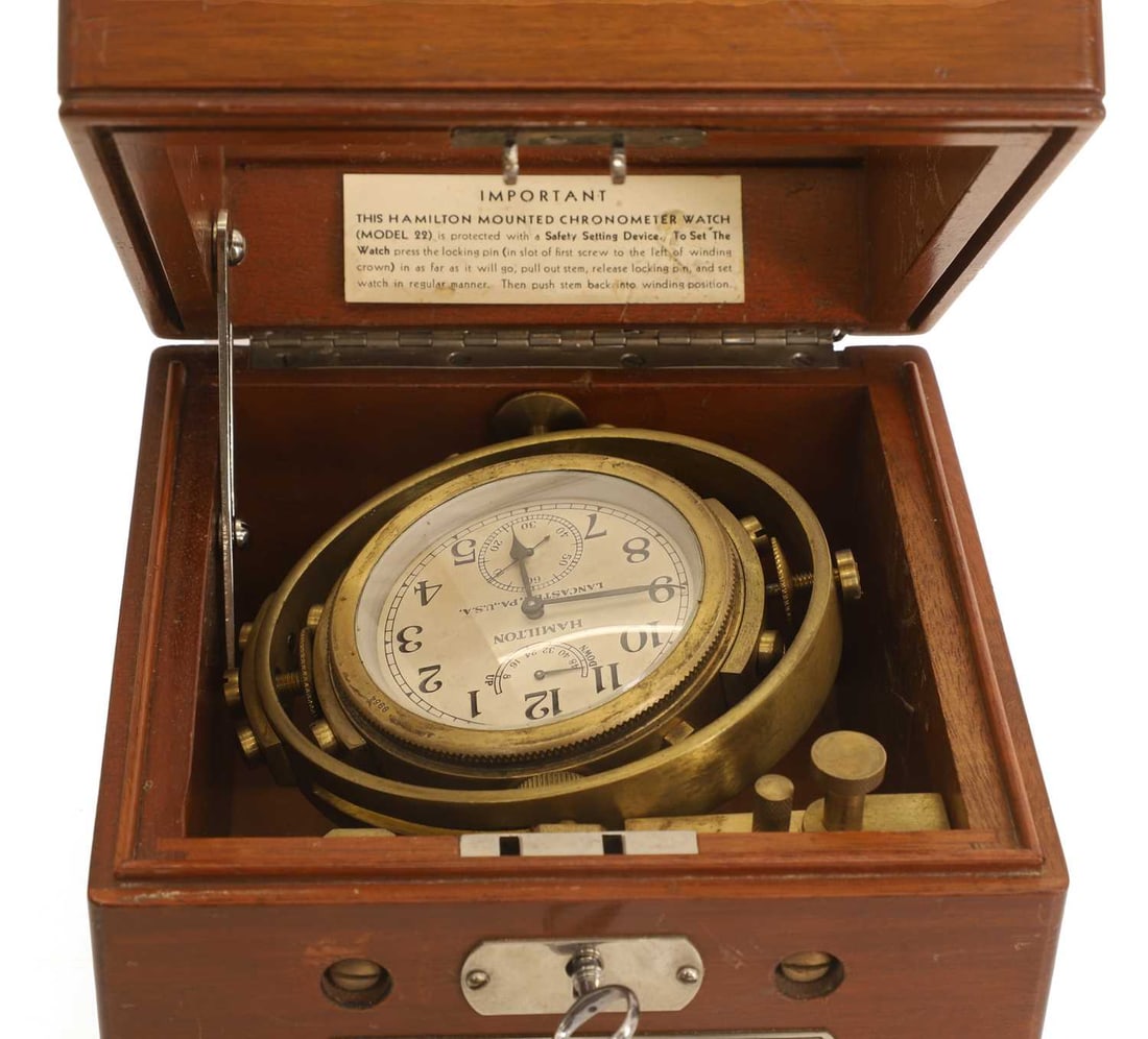 A WWII US Navy two-day chronometer watch, 'Model 22', by Hamilton Watch Co.,: A WWII US Navy two-day chronometer watch, 'Model 22', by Hamilton Watch Co., no.9954, with three-part case, slide catches and applied metal signature plaque, signed silvered Arabic dial with