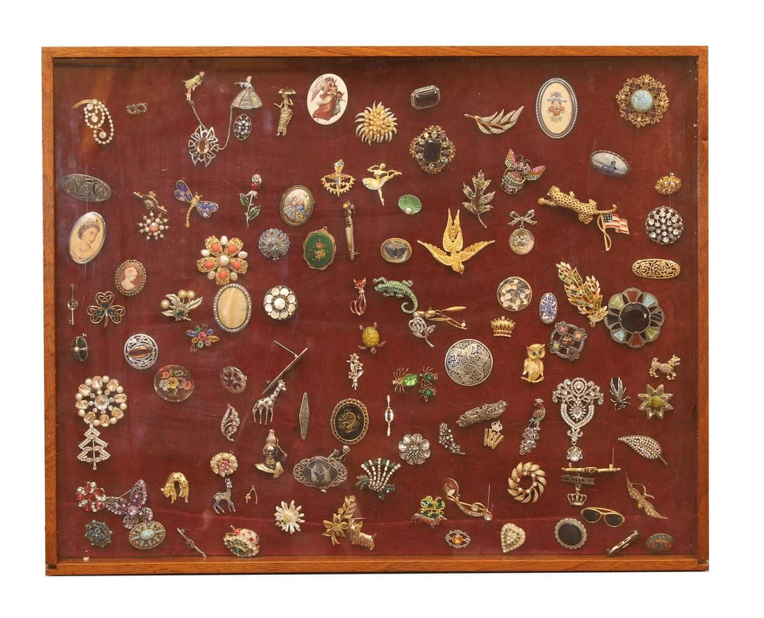 A collection of vintage jewellery brooches,: A collection of vintage jewellery brooches, to include a 9ct gold bar brooch set with a red paste stone, unmarked, tested as approximately 9ct gold, a wish bone brooch, stamped 375, tested as approxim