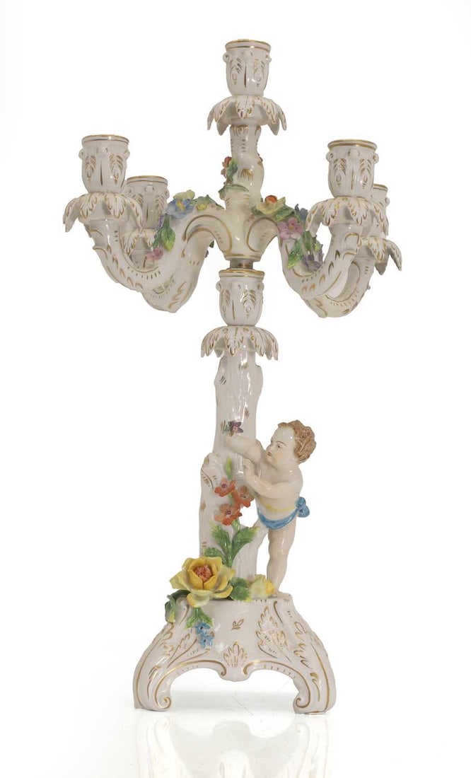 A Dresden four branch candelabra, late 19th cetury,: A Dresden four branch candelabra, late 19th cetury, with putti detail, and marking to underside 25cm wide, 51.5cm,