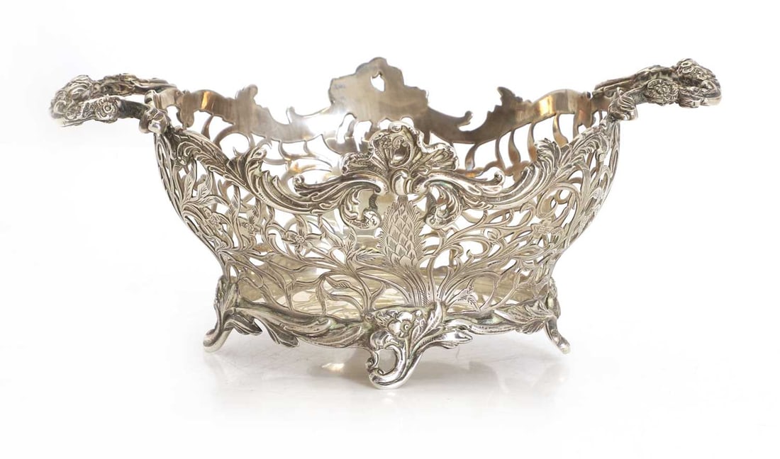 A Victorian silver bread basket, by William Comyns & Sons, 1898,: A Victorian silver bread basket, by William Comyns & Sons, 1898, twin-handled, with pierced scrolling foliate detail throughout 22.5cm wide, 14.5cm deep, 10.5cm high, 15.5ozt Condition Report: Good