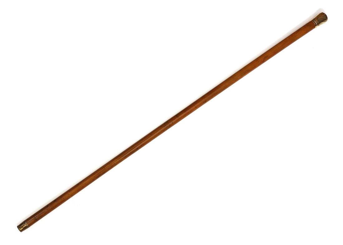 An 18ct gold-mounted walking cane, makers mark TJ, London 1888,: An 18ct gold-mounted walking cane, makers mark TJ, London 1888, with a spiral gadrooned pommel, the end engraved with a crest, with a Malacca shaft and metal ferrule 91cm long Condition Report: Some