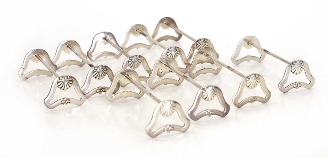 A set of nine silver knife rests, 20th century, Belgian: A set of nine silver knife rests, 20th century, Belgian each with pierced ends decorated with shell motifs, stamped '800' 9cm wide, 2.7cm high 9