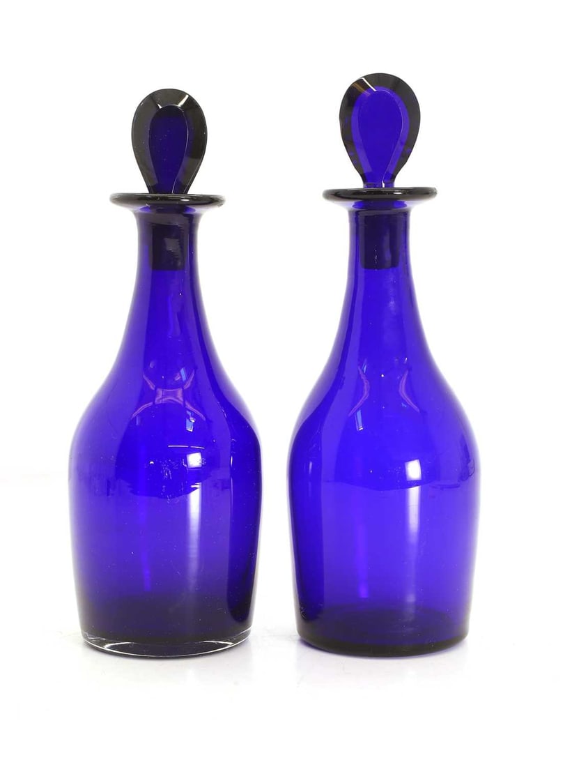 A pair of blue glass decanters and stoppers, George III,: A pair of blue glass decanters and stoppers, George III, each with a tear drop shaped stopper over a mallet shaped body 25.5cm high 4 Condition Report: Good