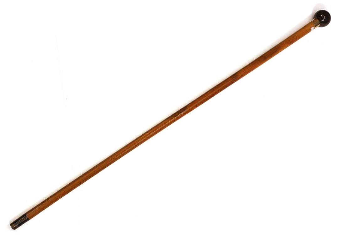 An 18ct gold and faux tortoiseshell walking cane by Thomas Johnson, London, 1886,: An 18ct gold and faux tortoiseshell walking cane by Thomas Johnson, London, 1886, with a sphere handle, inlaid with a crown over 'EE', the gold collar engraved 'Prebendary Buckingham 1932', a Malacca