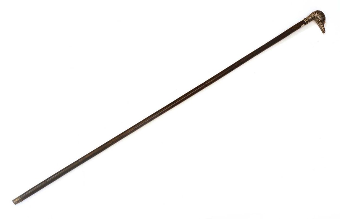 A silver-mounted duck's head walking cane, makers mark WD, London, 1900,: A silver-mounted duck's head walking cane, makers mark WD, London, 1900, with glass eyes, mounted on a Partridge wood shaft with a brass ferrule 88cm long Condition Report: Ferrule worn. Some marks