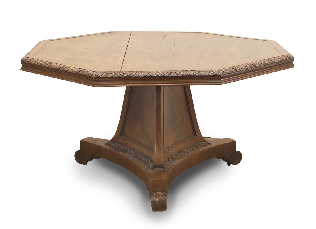A Regency mahogany centre table, circa 1820,: A Regency mahogany centre table, circa 1820, the octagonal top with a foliate-carved border, raised on a tripartite base terminating in scrolling supports 138cm diameter, 74cm high