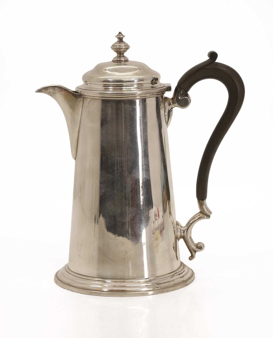 A George V silver coffee pot,: A George V silver coffee pot, by Martin Hall & Co Ltd, Sheffield, 1912, with an ebonised handle and stepped base 18cm wide, 22cm high, total 17.7ozt