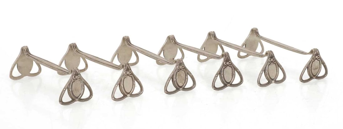 A group of six silver knife rests, circa 1900, Belgian: A group of six silver knife rests, circa 1900, Belgian by Wolfers Freres, with pierced ends decorated with a vacant cartouche with ribbon swags, stamped '800' 10cm wide, 3.2cm high, 6.1ozt 6
