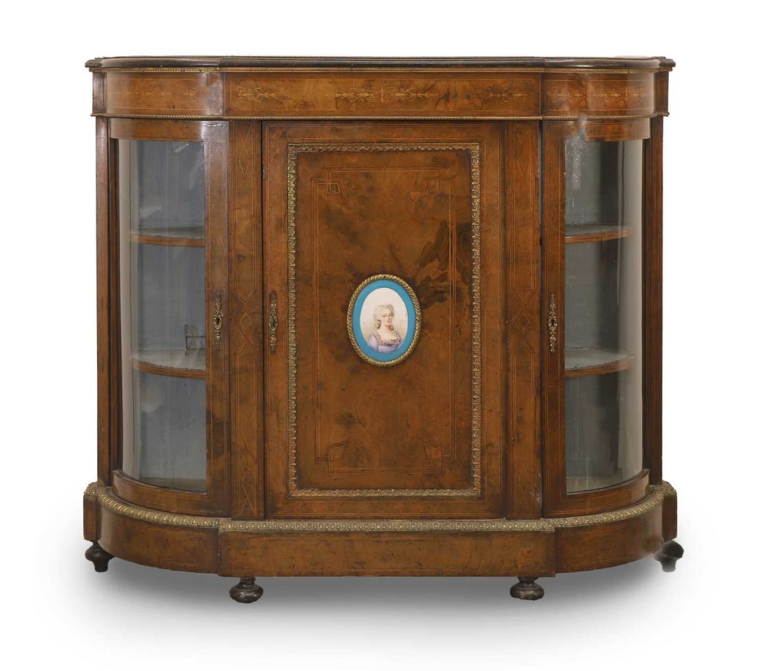 A Victorian walnut credenza, 19th century,: A Victorian walnut credenza, 19th century, the central door with Sèvres style panel, covering a single shelf, the centre flanked by two curved glass doors opening to reveal shelves 121.5cm wide,