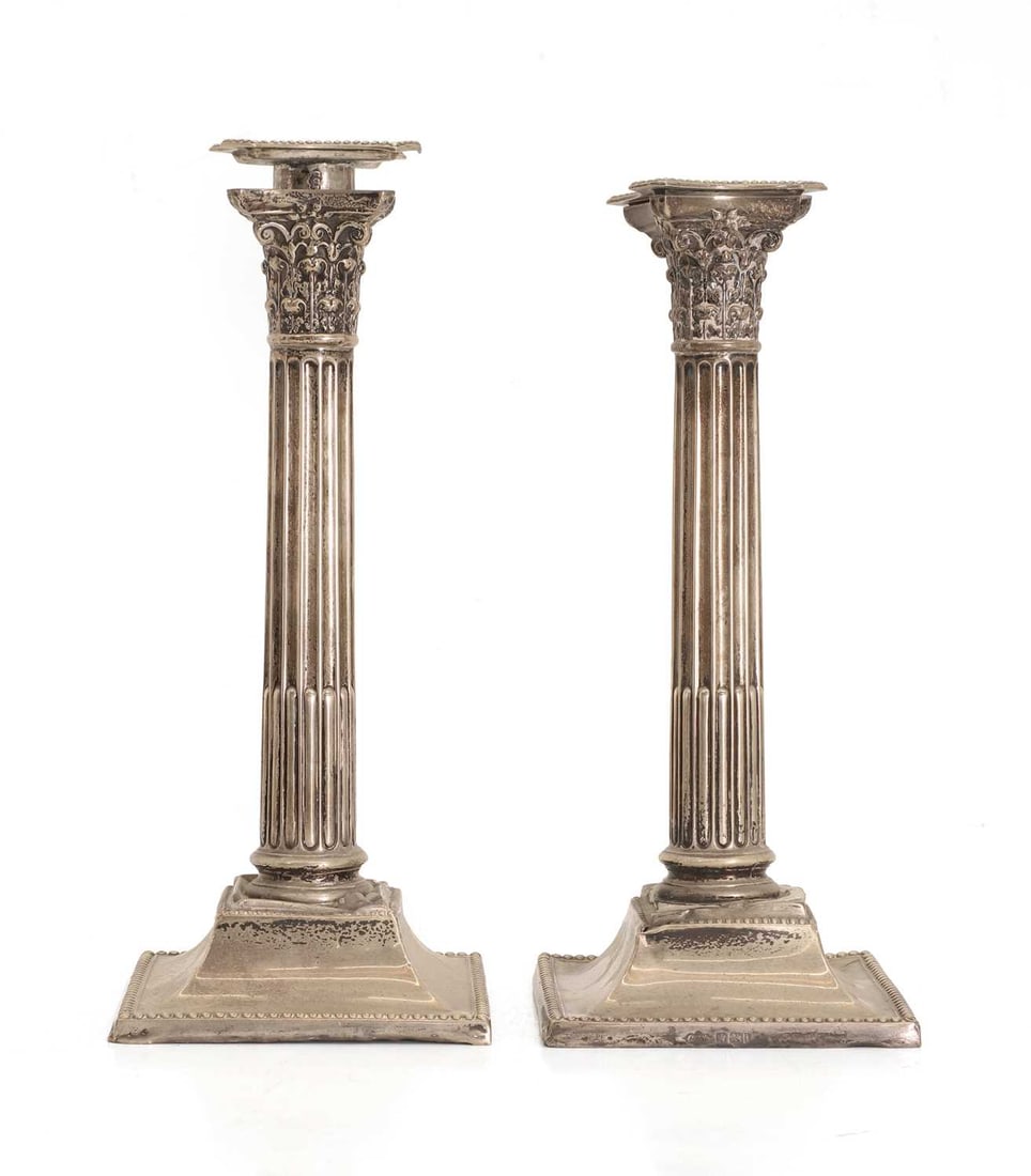 A pair of silver candlesticks,: A pair of silver candlesticks, by Sibray, Hall & Co Ltd (Charles Clement Pilling), Sheffield, 1901, with Corinthian columns, with beaded square bases, filled 10.5cm wide, 24cm high, total 28.1ozt