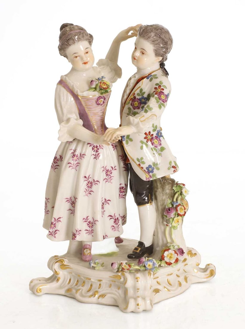 A Meissen figural group, late 19th century,: A Meissen figural group, late 19th century, designed by August Ringler, two children dancing, the boy in a floral jacket and girl in a purple dress, model number 174, with blue crossed sword marks to 