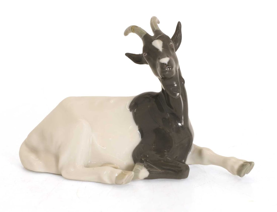 A Meissen model of a goat 20th century,: A Meissen model of a goat 20th century, seated, the body in grey and white, incised V126 or 726 to base with crossed swords 9.5cm long, Condition Report: damaged and repaired to horn