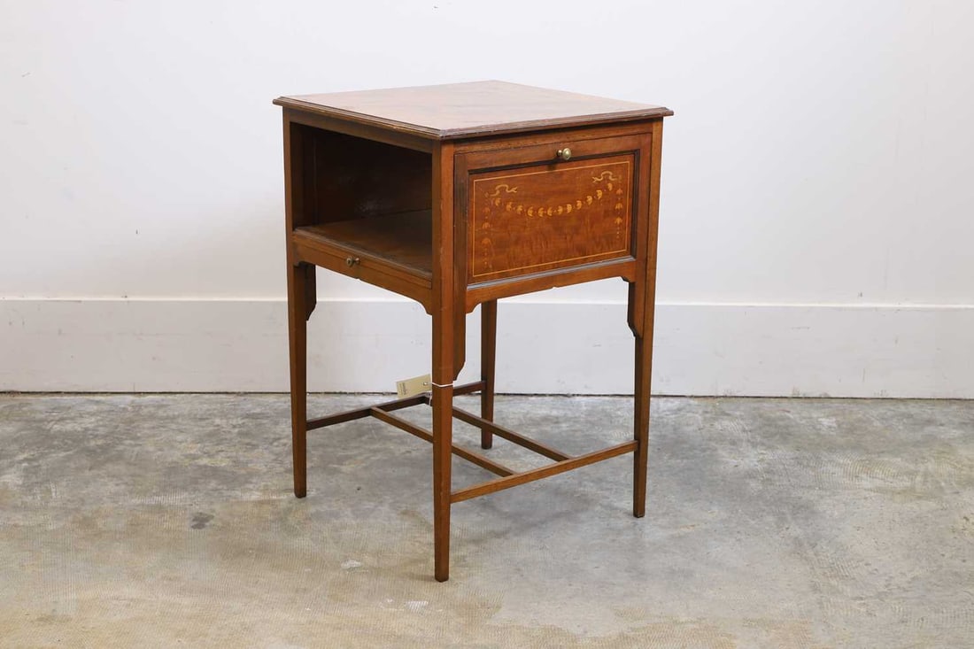 An Edwardian drop flap bedside table, 20th century,: An Edwardian drop flap bedside table, 20th century, the drop leaves with inlaid swag decoration, the square legs united by a stretcher 49cm wide, 73cm high