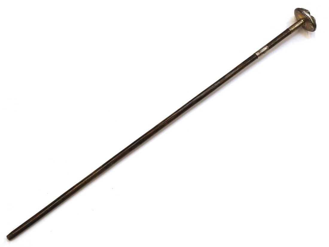 A silver-mounted walking cane, makers mark EB, London, 1902,: A silver-mounted walking cane, makers mark EB, London, 1902, the oval handle embossed with a bird, with a red eye, on a Partridge wood shaft, with a silver collar 89cm long Condition Report: Shaft wit