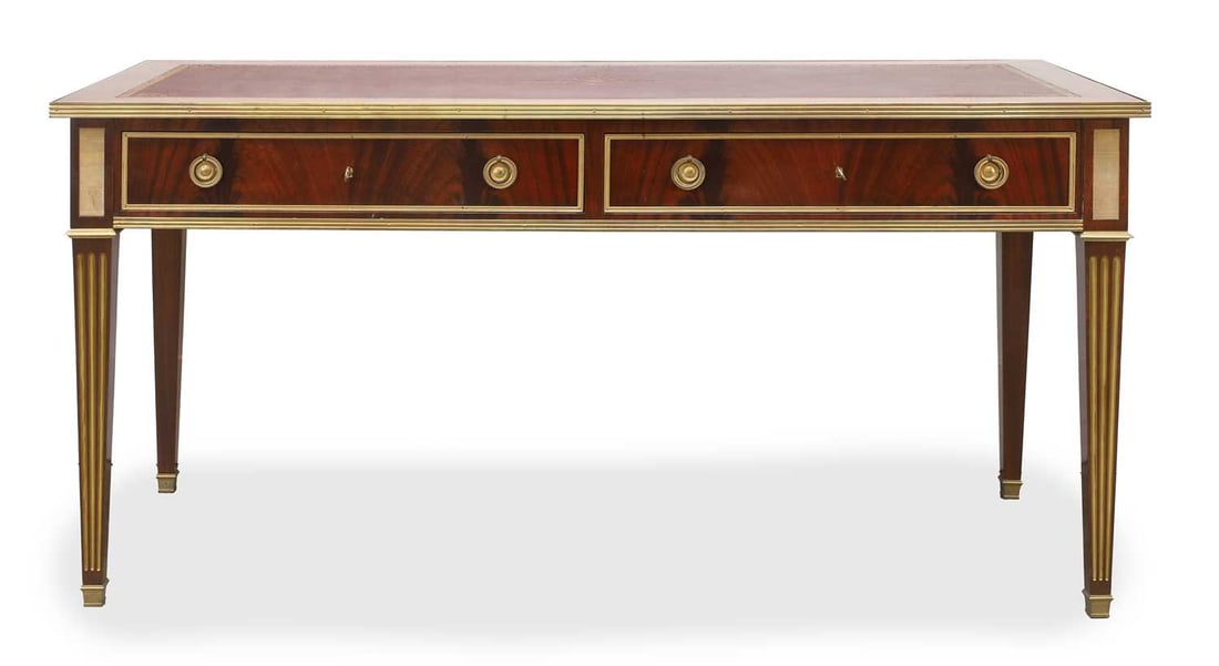 A Louis XVI-style mahogany and gilt-brass bureau plat, early 20th century, French,: A Louis XVI-style mahogany and gilt-brass bureau plat, early 20th century, French, with a gilt-tooled leather top over two twin pull drawers with faux examples to the reverse, over square tapering flu