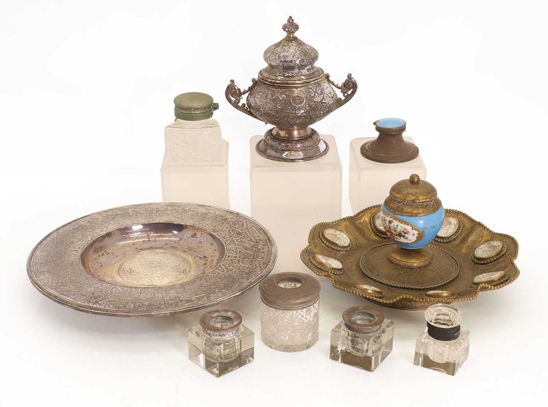 A Middle Eastern white metal inkstand,: A Middle Eastern white metal inkstand, together with a gilt metal inkstand with inset cameo plaques to the scalloped rim, and blue porcelain inkwell to the centre, together with additional examples