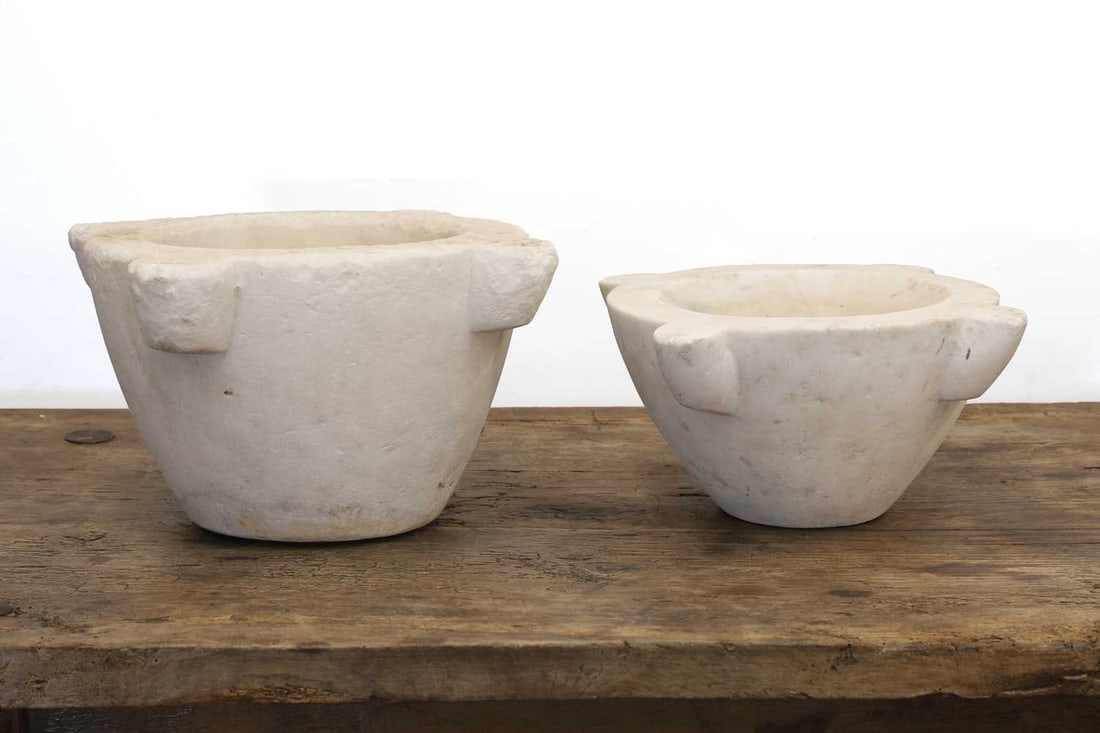Two stone mortars,: Two stone mortars, both with four shaped edges and circular recesses to the centre The largest, 35cm wide, 20cm high 2