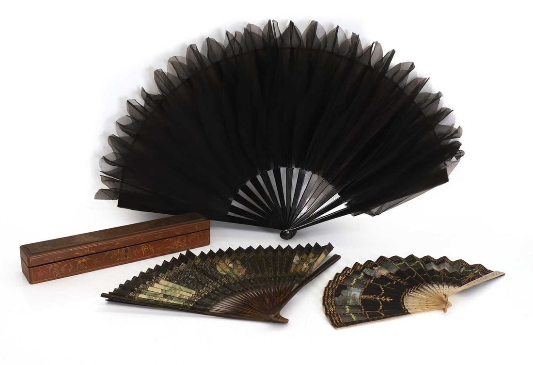A collection of three fans,: A collection of three fans, to include a Chinese fan with landscape decorated reserves, housed in a red lacquer box with hand-painted floral design, together with a black ostrich feather style fan,