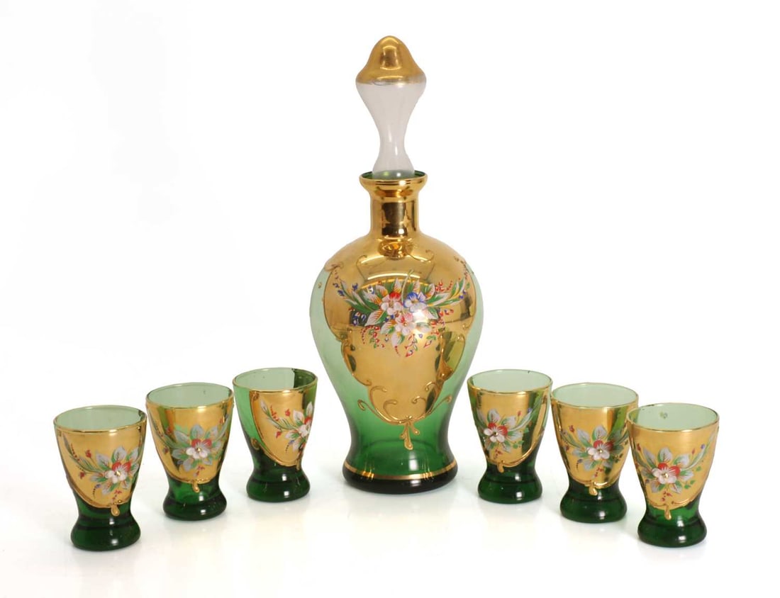 A collection of Murano green glass and gilt liquor set,: A collection of Murano green glass and gilt liquor set, comprising a decanter and six tumblers, all with gilt decoration and flower blooms Decanter, 26cm high 7 Condition Report: Some fading to the
