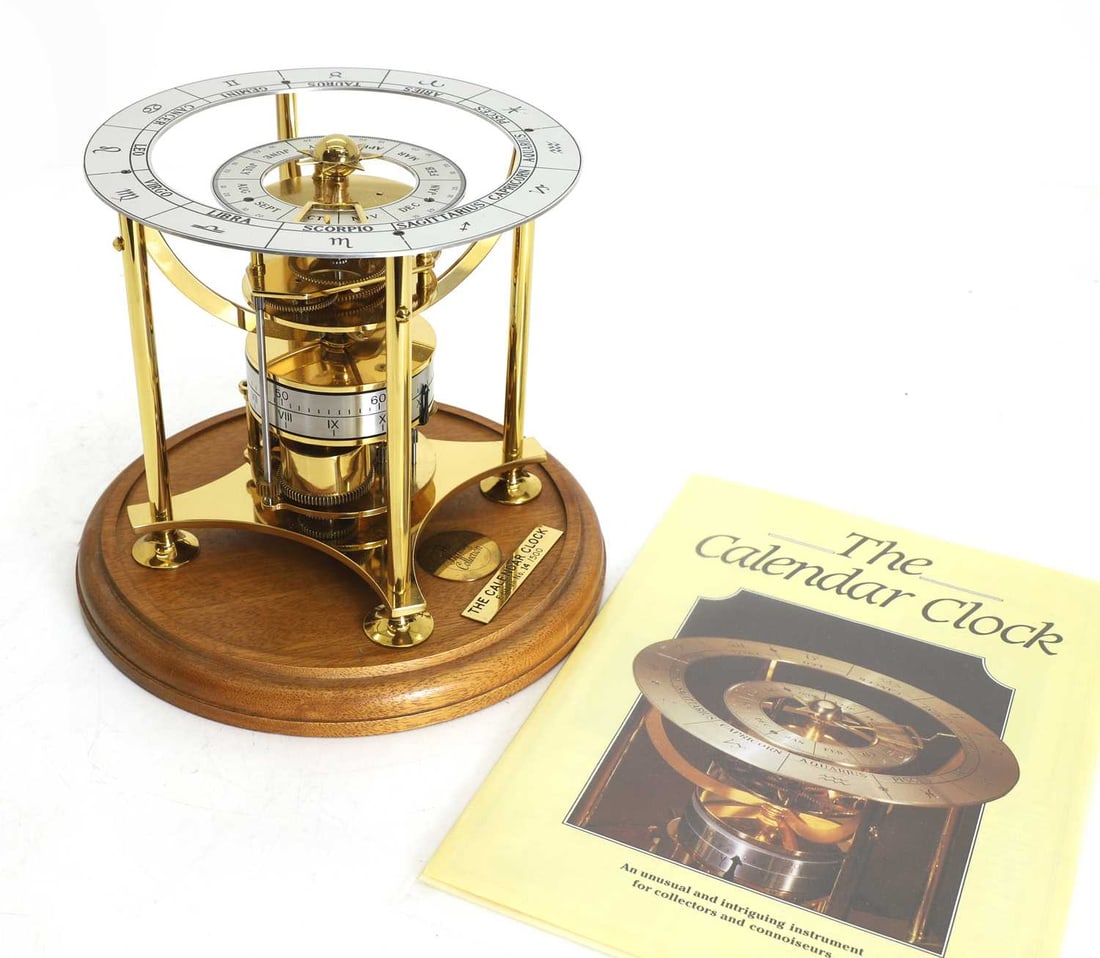 A Heritage Collection calendar clock,: A Heritage Collection calendar clock, numbered 14/500, the skeleton movement with time, date, and zodiac calendar, cased in wooden and glass dome, with paperwork 24cm wide, 33cm high