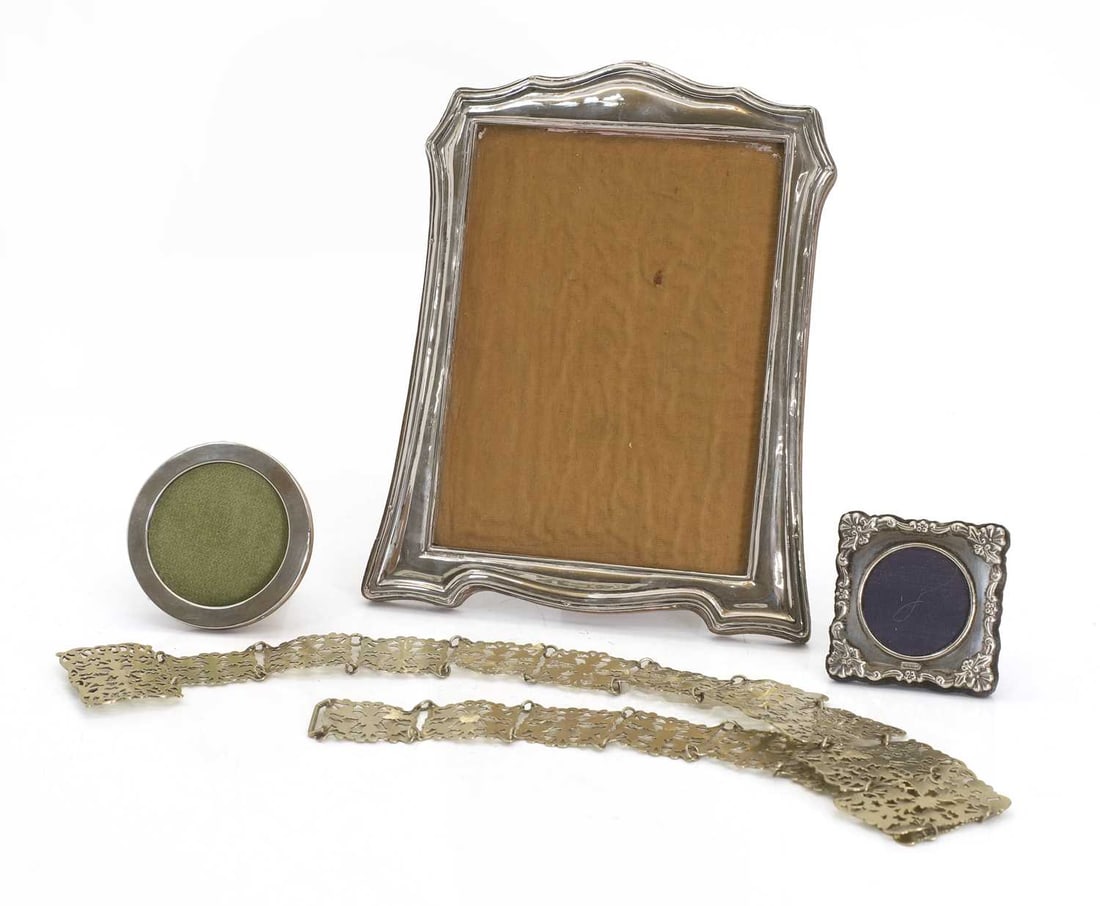 A silver photograph frame, by Green & Cadbury Ltd., Birmingham, 1919,: A silver photograph frame, by Green & Cadbury Ltd., Birmingham, 1919, with an easel back, and two smaller photograph frames, and a silver-plated pierced nurse's belt 25 x 20cm, internal, 19 x 14, 8cm