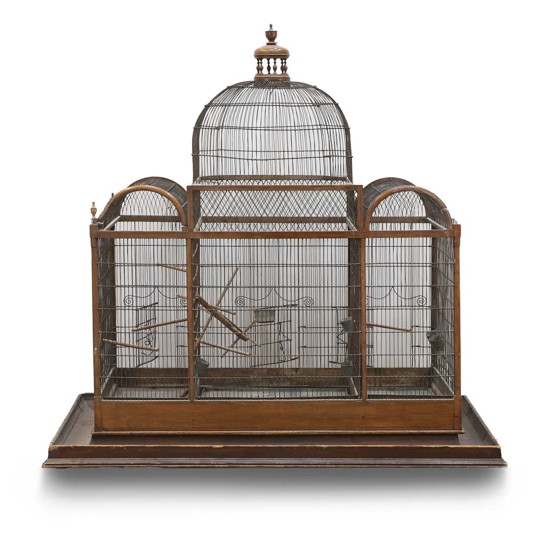 A large wooden and wirework bird cage, late 19th century,: A large wooden and wirework bird cage, late 19th century, the domed central roof with a final, flanked by two semi circular ceiling sections over a moulded floor on castors `131cm long, 76cm deep,