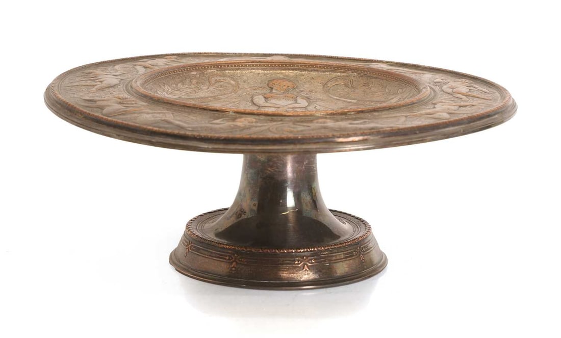 A silver plated tazza,: A silver plated tazza, possibly by Elkington & Co Ltd, the central field depicting Venus and two cherubs, and the rim decorated with cherubs in flight holding ribbon swags, stamped marks to the
