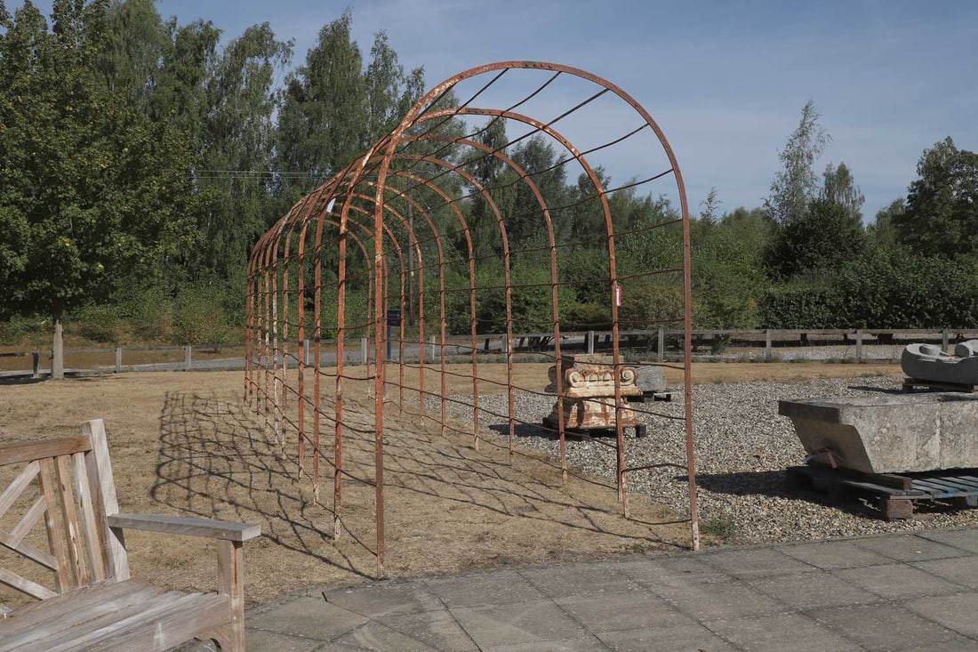 A large wrought iron rose arch, early 20th century,: A large wrought iron rose arch, early 20th century, the semi cirular form top above straight supports, with previous white paint, in nine sections 164cm wide, 827cm long, 245cm high, Condition