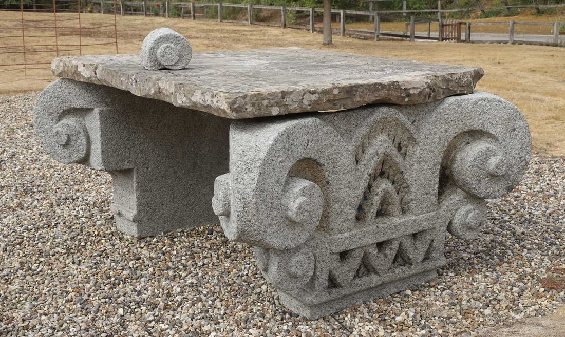 A granite capital dessert table, early 20th century,: A granite capital dessert table, early 20th century, with large York stone slab top, each large capital support detailed and carved 166 wide, 184cm deep, 103m high Condition Report: one scroll