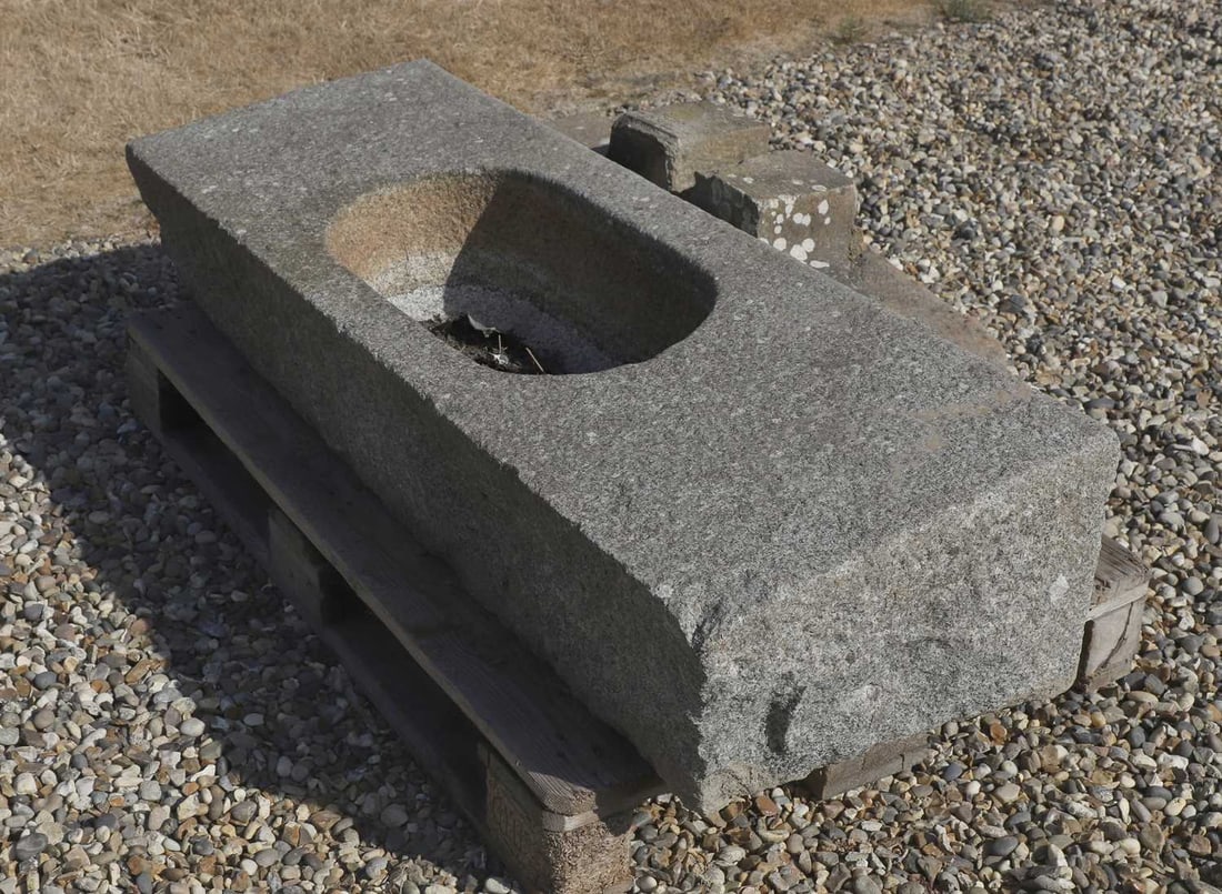 A granite trough on stand, 20th century,: A granite trough on stand, 20th century, the body of tapering rectangular form with an ovular centre carved bowl, over rectangular supports 144cm wide, 47cm deep, 50cm high Condition Report: Would