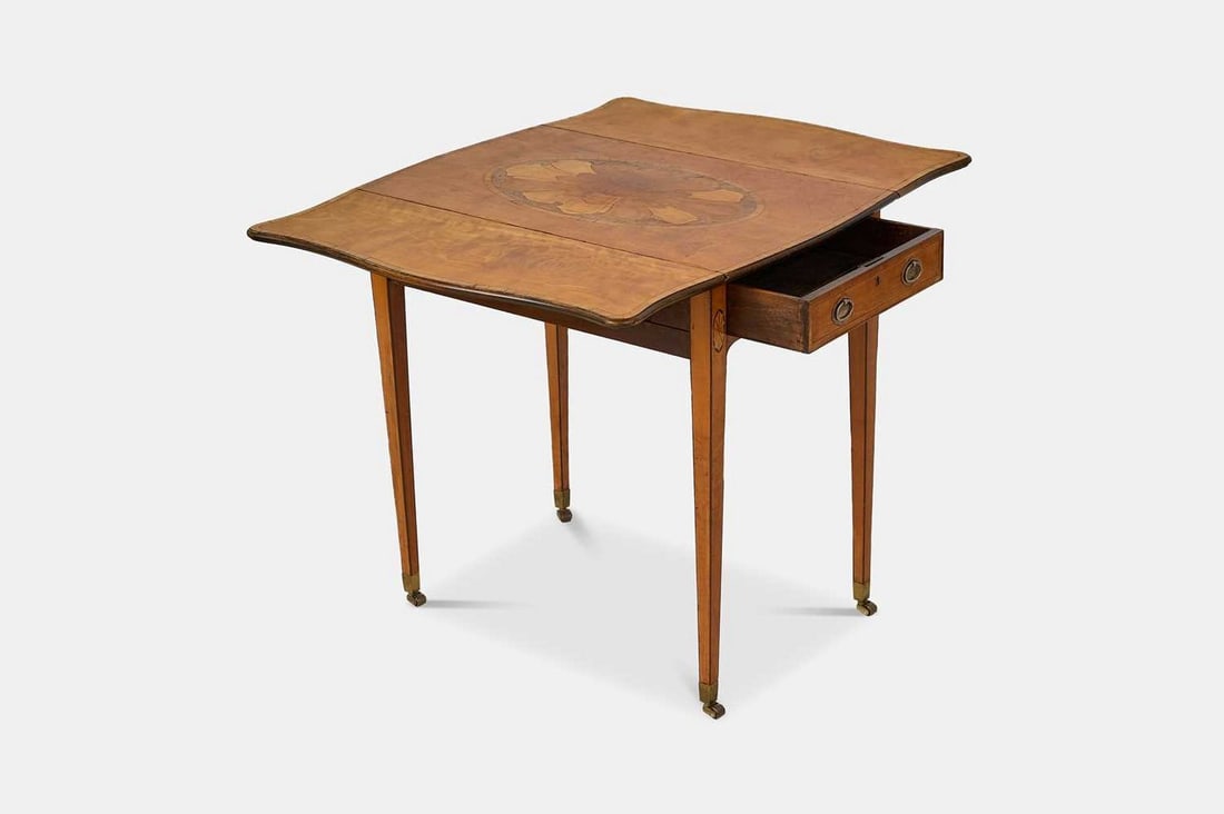 A George III satinwood, rosewood and burr yew Pembroke table, circa 1780, in the manner of Thomas: A George III satinwood, rosewood and burr yew Pembroke table, circa 1780, in the manner of Thomas Chippendale, the crossbanded serpentine top inlaid with a central shell medallion, above a single shor