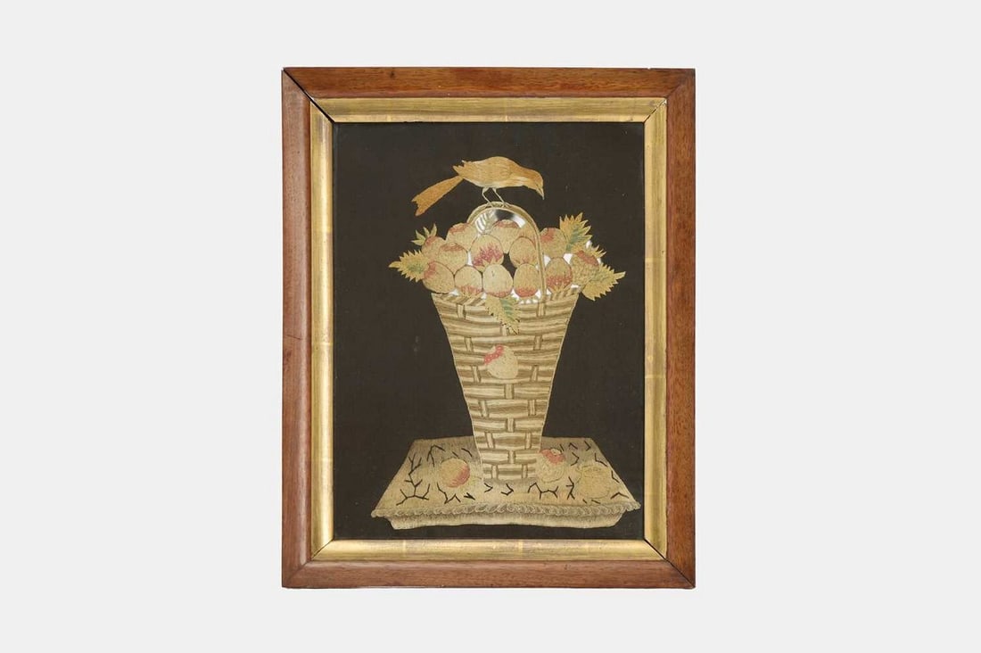 A George III silk needlework picture, late 18th/early 19th century,: A George III silk needlework picture, late 18th/early 19th century, embroidered in multicoloured threads, depicting a strawberry plant in a basket with a bird perched on top, on a black silk ground (n