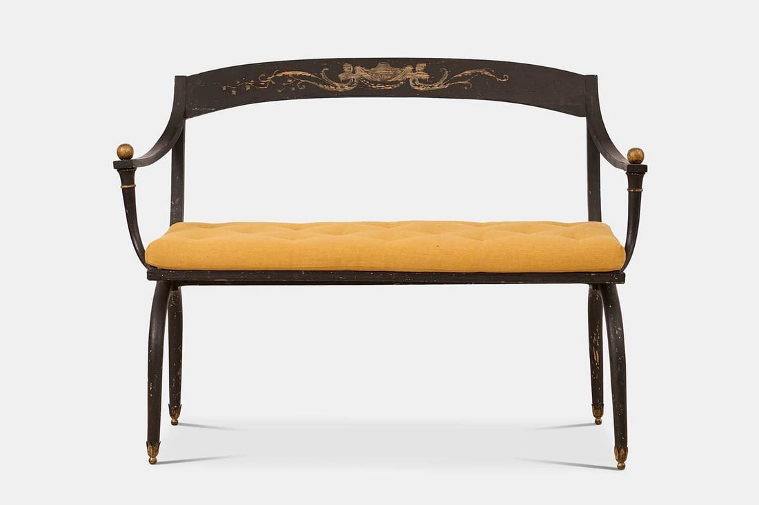 A neoclassical painted wooden hall bench, late 19th century, in the manner of Jean-Joseph Chapuis,: A neoclassical painted wooden hall bench, late 19th century, in the manner of Jean-Joseph Chapuis, the curved top rail centred by an urn flanked by classical heads and scrolling foliate detail, over a
