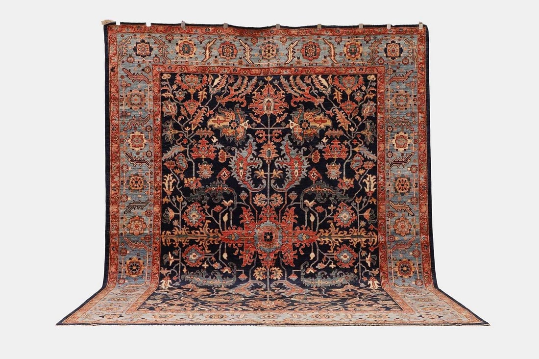 A wool carpet of antique Heriz design, of recent manufacture,: A wool carpet of antique Heriz design, of recent manufacture, woven with scrolling foliate motifs to a blue ground (356 x 271cm) Condition Report: Overall the piece presents in very good structural an
