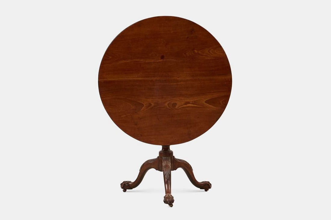 A George III mahogany tripod table, third quarter of the 18th century,: A George III mahogany tripod table, third quarter of the 18th century, the circular top above a birdcage and wrythen-turned column, raised on carved outswept ball-and-claw supports (91cm diameter, 74c