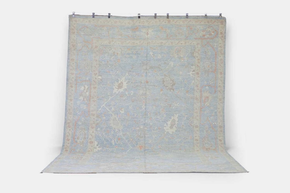 An Oushak wool carpet, of recent manufacture, Anatolian,: An Oushak wool carpet, of recent manufacture, Anatolian, woven with scrolling foliate motifs to a pale-blue ground (355 x 265cm) Condition Report: Overall the piece presents in very good structural an