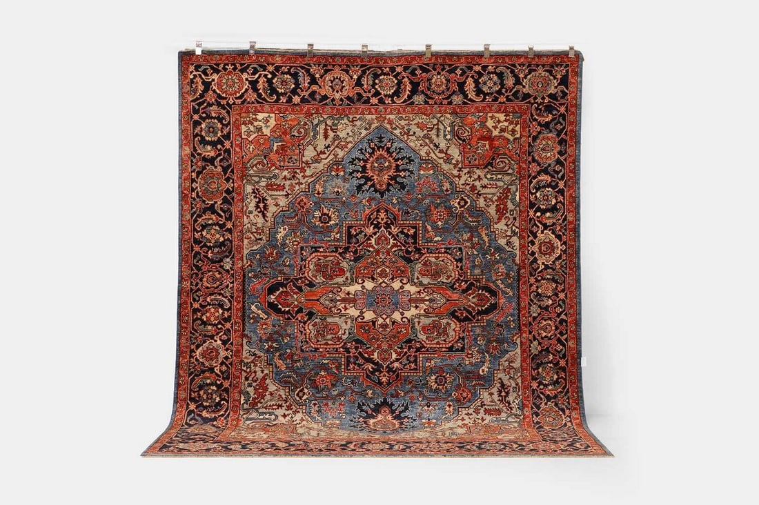 A wool carpet of Heriz design, of recent manufacture,: A wool carpet of Heriz design, of recent manufacture, woven with geometric foliate motifs to a blue ground (301 x 244cm) Condition Report: Overall the piece presents in very good structural and cosmet