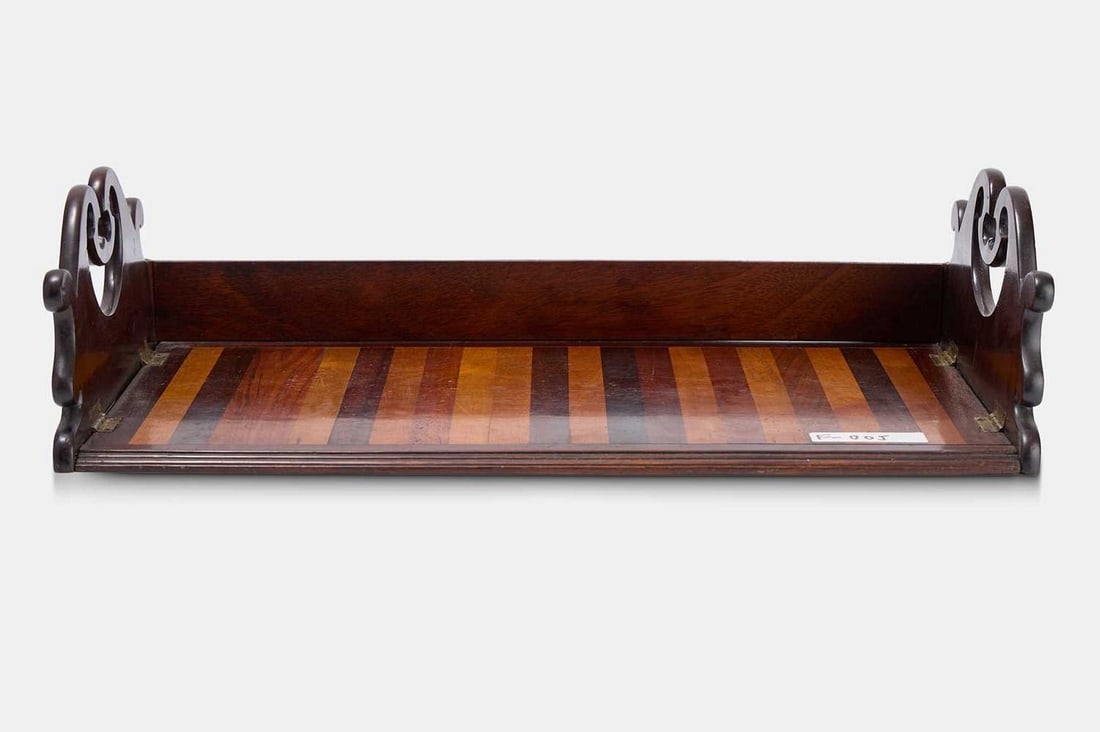 A small Regency bookrack, circa 1820,: A small Regency bookrack, circa 1820, composed of various specimen woods, with pierced folding handles (42cm wide, 23cm deep, 11cm high) Provenance:: The Tim Wonnacott collection. Condition Report: Go