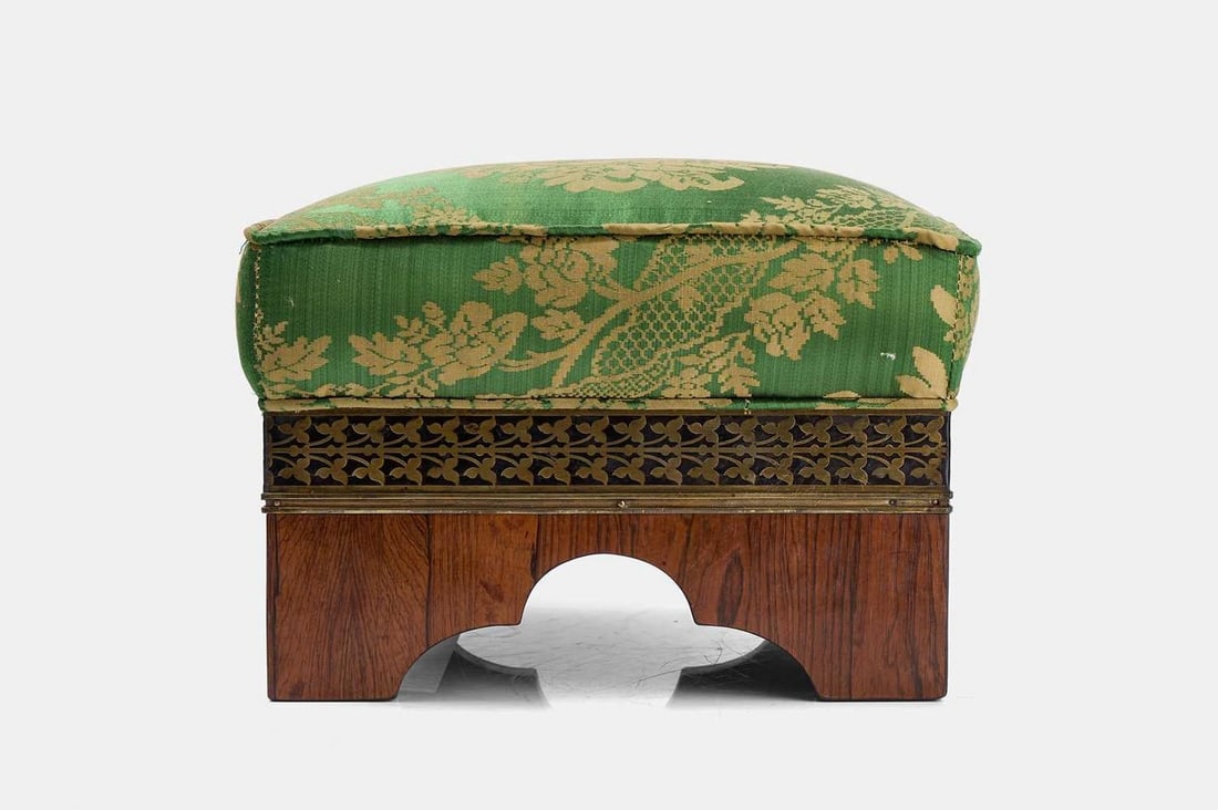 A Regency upholstered rosewood and brass footstool, circa 1820, in the manner of George Bullock,: A Regency upholstered rosewood and brass footstool, circa 1820, in the manner of George Bullock, covered in green and gold silk brocade upholstery, the frame decorated with a brass-inlaid floral borde