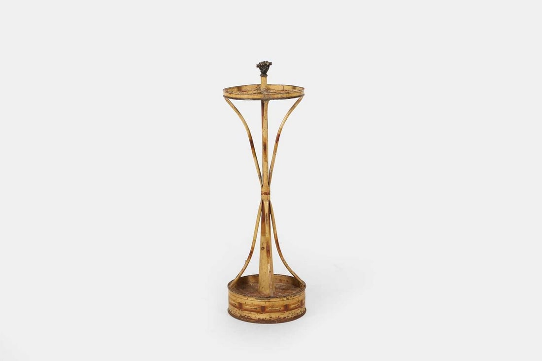 A Regency painted faux bamboo toleware stick stand, circa 1820,: A Regency painted faux bamboo toleware stick stand, circa 1820, surmounted by a finial in the form of a clenched fist, with four swept supports terminating in a dished base (24cm base diameter, 77cm h