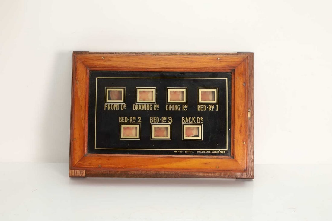 A mahogany cased servants' bellboard, circa 1900,: A mahogany cased servants' bellboard, circa 1900, inscribed 'Harry Smith, St Albans, Phone: 1880' (39cm wide, 8cm deep, 27cm high) Condition Report: Comsetically, the board is in fairly good condition