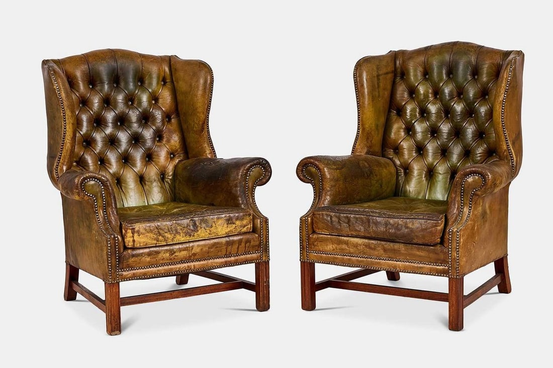 A pair of Victorian-style leather wing armchairs, 20th century,: A pair of Victorian-style leather wing armchairs, 20th century, each covered in green leather upholstery, with a buttoned back over a drop-in cushion seat flanked by roll arms, raised on straight cham