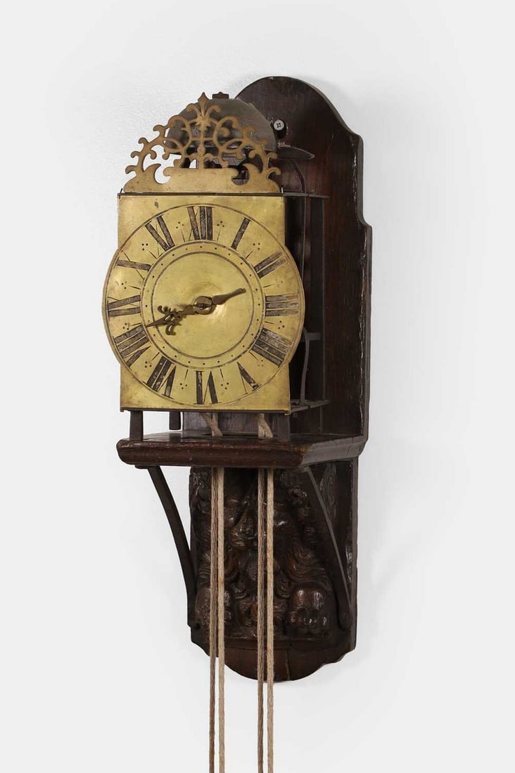 A William III brass lantern clock, circa 1700,: A William III brass lantern clock, circa 1700, unsigned, the pierced fretwork pediment above a 7-inch Roman chapter ring, with a weight-driven birdcage movement striking on a bell, mounted on a carved