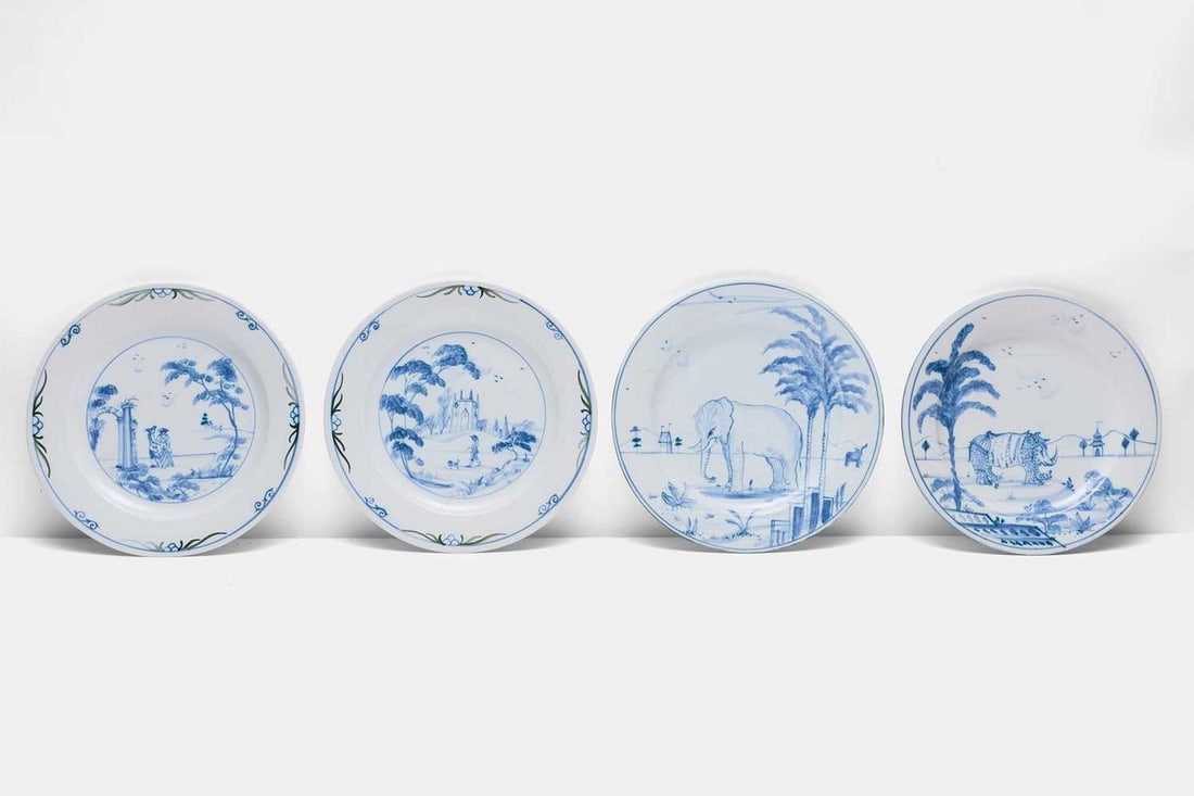 Four hand-painted delft-style plates by Isis Ceramics, late 20th century, for Sibyl Colefax and John: Four hand-painted delft-style plates by Isis Ceramics, late 20th century, for Sibyl Colefax and John Fowler, comprising two from the 'Exotic Animal' series, depicting an elephant and rhinoceros respec