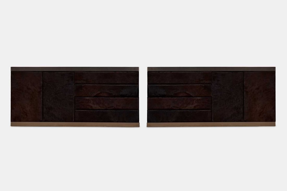 A pair of fur-covered sideboards, of recent manufacture,: A pair of fur-covered sideboards, of recent manufacture, each with four long drawers, flanked to one side by a pair of cupboard doors enclosing a void interior, lacking shelves (181cm wide, 50cm deep,