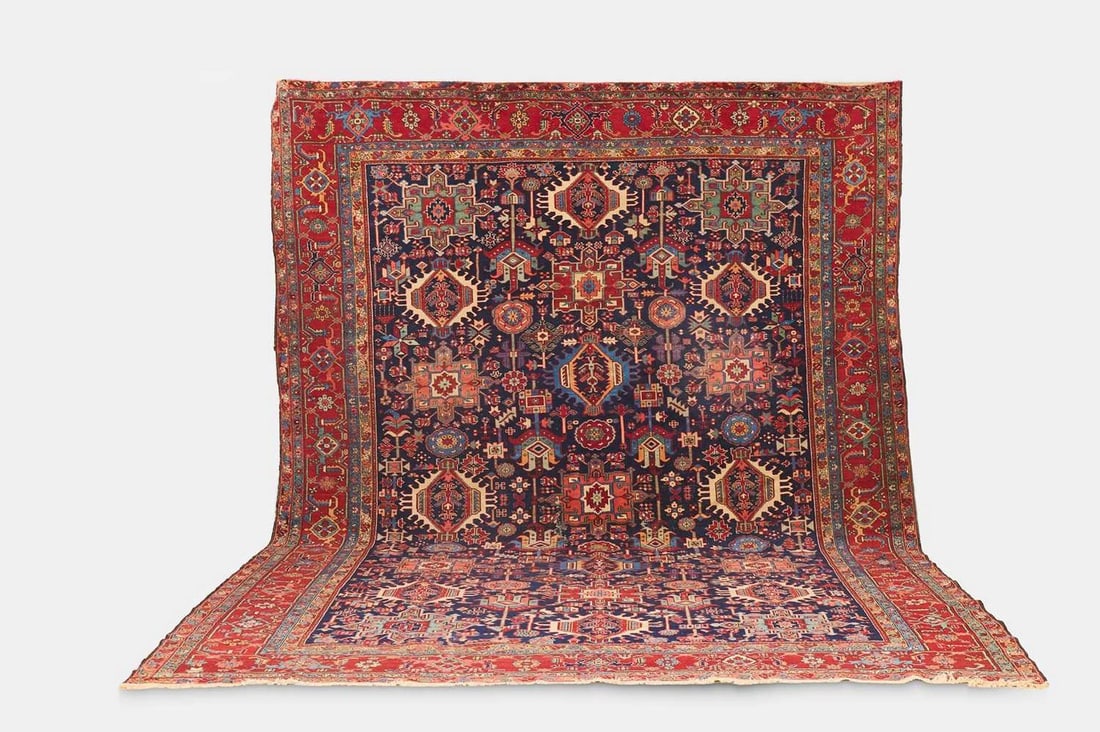 A large Persian Heriz wool carpet, 20th century,: A large Persian Heriz wool carpet, 20th century, the indigo field woven with geometric and foliate motifs (450 x 340cm) Condition Report: Please note: although we try to reproduce colours as closely a