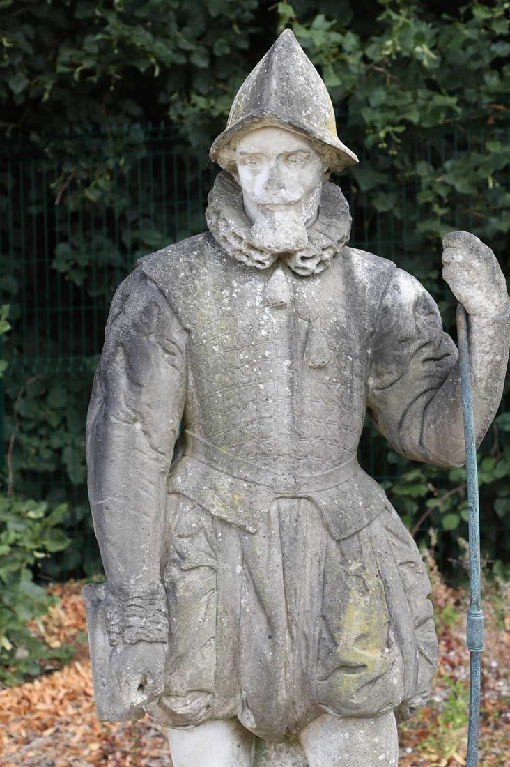 A carved marble figure of a Tudor figure, late 19th/early 20th century,: A carved marble figure of a Tudor figure, late 19th/early 20th century, modelled in typical attire with a pointed helmet, raised on an integral plinth base (63cm wide, 52cm deep, 171cm high) Condition